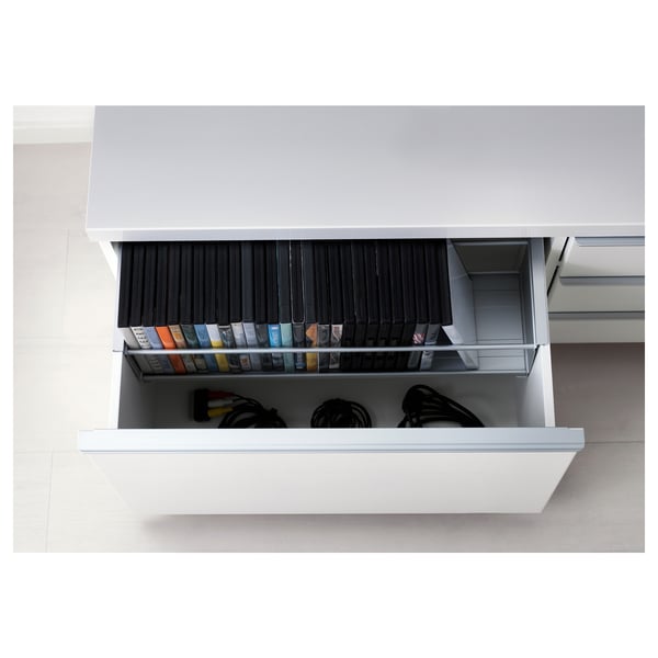 Open bestå tv bench with drawers showing organised electronics, cables, and game accessories.