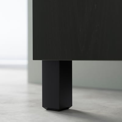 Black BESTÅ furniture leg, hexagon-shaped, on light floor.