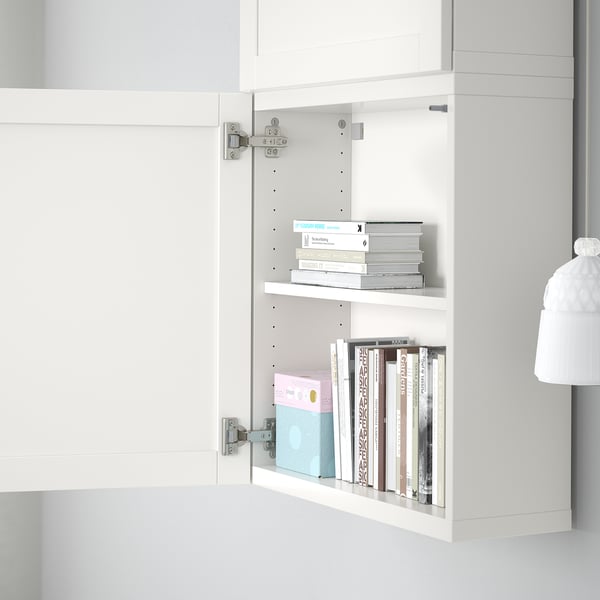 Open white cabinet with adjustable shelves holding various books, showing customizable storage.