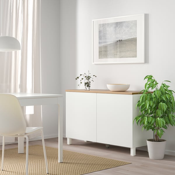 White BESTÅ furniture with adjustable shelves, decorative top.