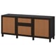 A black BESTÅ sideboard with wicker doors, featuring drawers and shelves for storage.