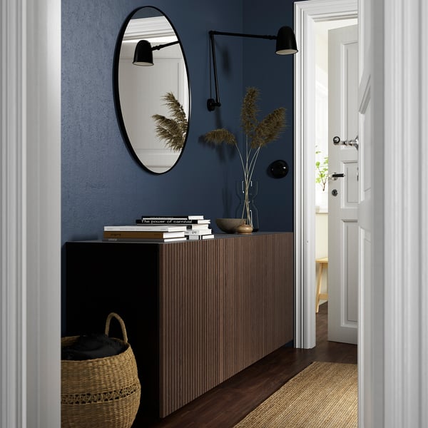 Modern entryway with BESTÅ console, mirror, sconces, and decor.