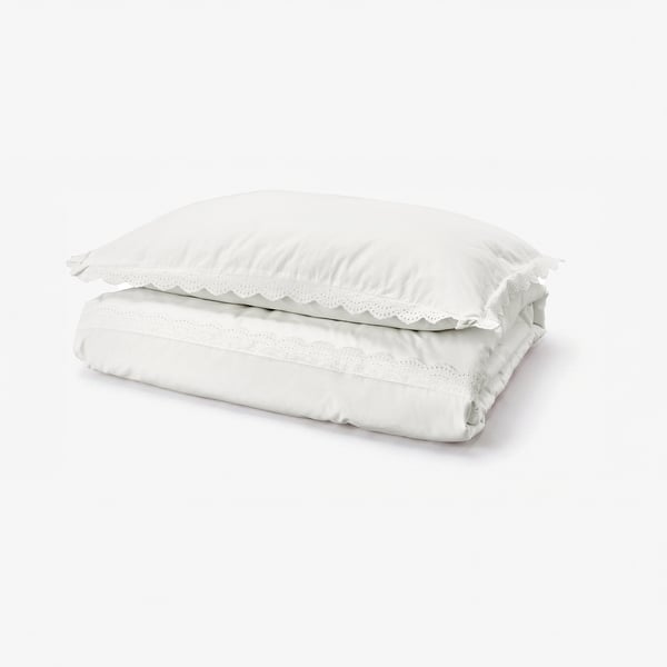 Folded white cotton duvet cover with lace trim. Classic design, soft texture.