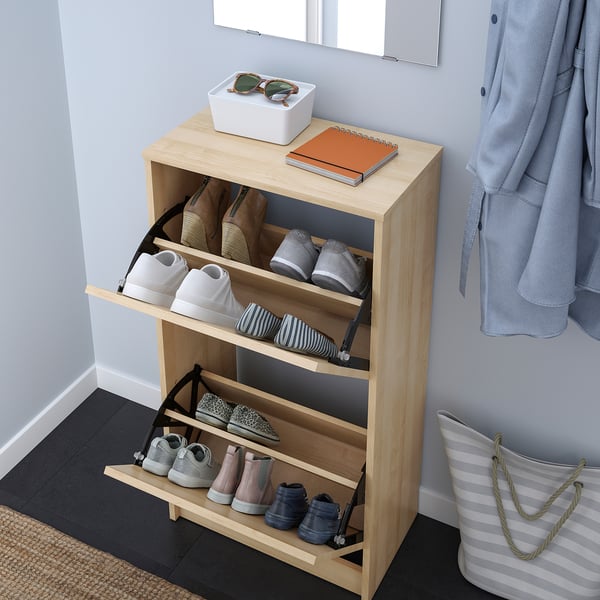 Shoe cabinet organising footwear, with dividers adjustable for varied sizes, keeping them ventilated and neat.