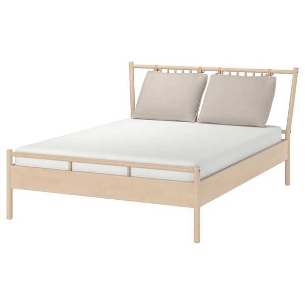 BJÖRKSNÄS bed with light wood frame and beige pillows.