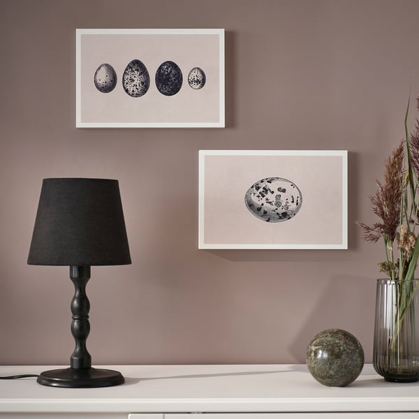 A stylish wall art set, framed and ready to hang or stand, displayed on a shelf with a lamp and vase.