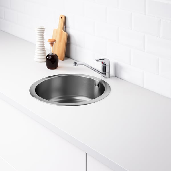 Stainless steel sink with tap on white countertop. Includes sound-absorbing material under the sink to reduce noise.