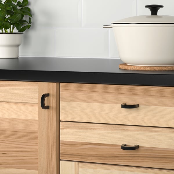 Modern kitchen with wooden cabinets and metal handles.