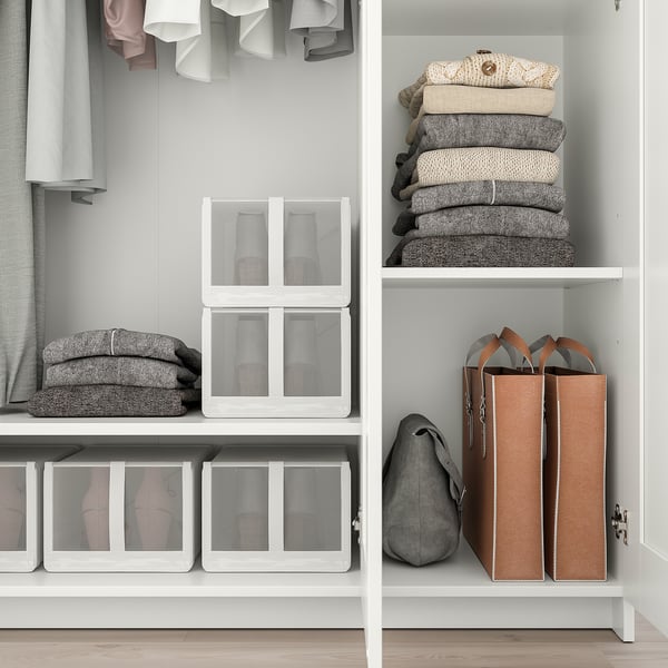 Closet with mirror door, shelves, stacked clothes, and boxes.