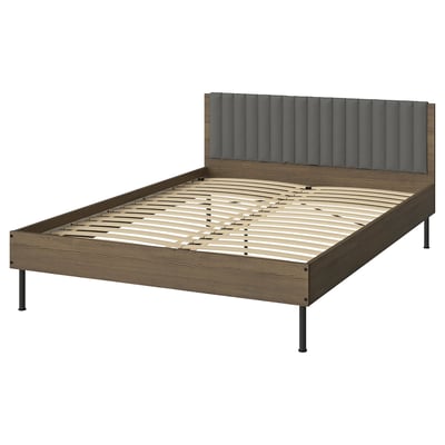 BRUKSVARA bed: brown wood finish frame, grey padded headboard, metal legs, minimalist design.