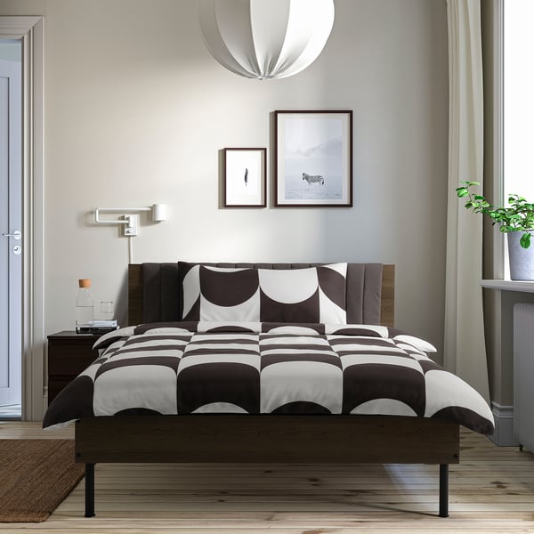 Modern bedroom with BRUKSVARA bed, wall art, plant, curtains.