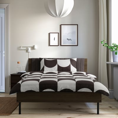 Modern bedroom with BRUKSVARA bed, wall art, plant, curtains.