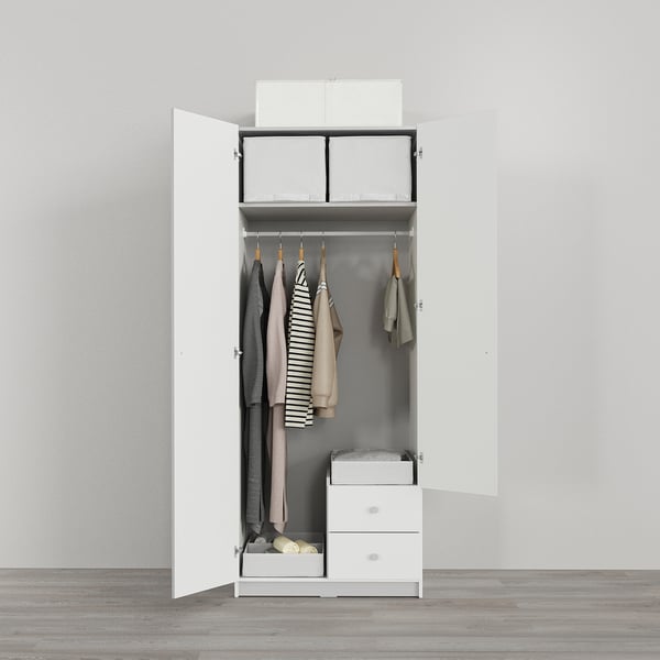 White wardrobe open, displaying clothes, drawers, shelves, and storage boxes. Back wall hooks hold additional items.