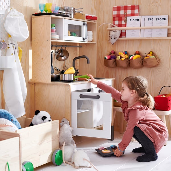 Girl playing with DUKTIG wooden kitchen, stuffed animals. Kid plays with DUKTIG wooden kitchen, includes tap & stuffed animals.