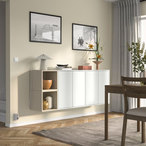 White EKET storage in living room with decor, photos, and wooden chairs.