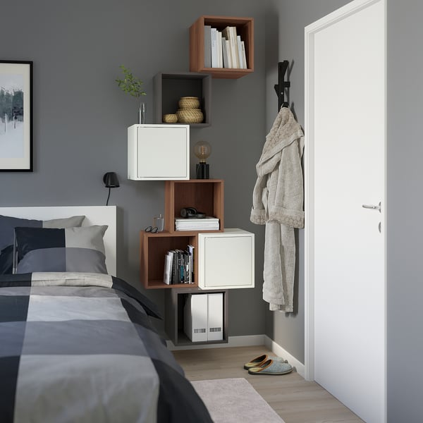 EKET modular storage in bedroom, mix of white/wood cubes, gray/white bedding, organised.