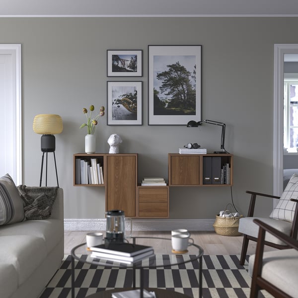 Modern living room with grey walls, EKET cabinets, striped rug, grey sofa, and glass-topped coffee table.