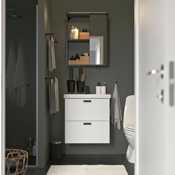 Modern bathroom with ENHET white cabinet and mirror. Wall-mounted, sleek design, matching grey towels and accessories.