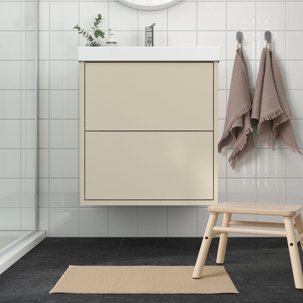 Minimalist bathroom with beige FINTSEN bath mat made of recycled polyester, blending with neutral decor.