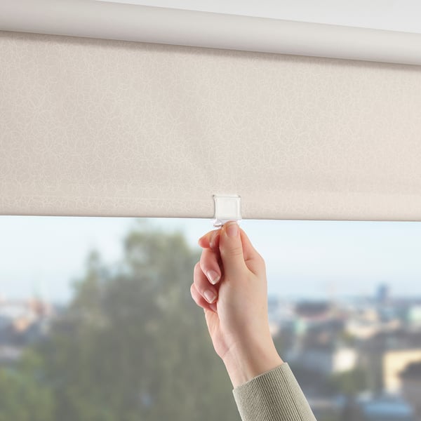 Hand adjusting FÖNSTERBLAD roller blind blocking light silently.