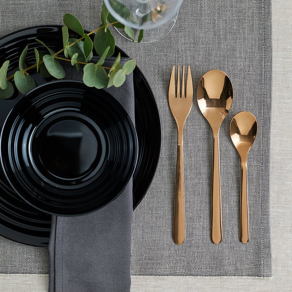 Gold cutlery set on black plate. Elegant & durable for special or daily use.