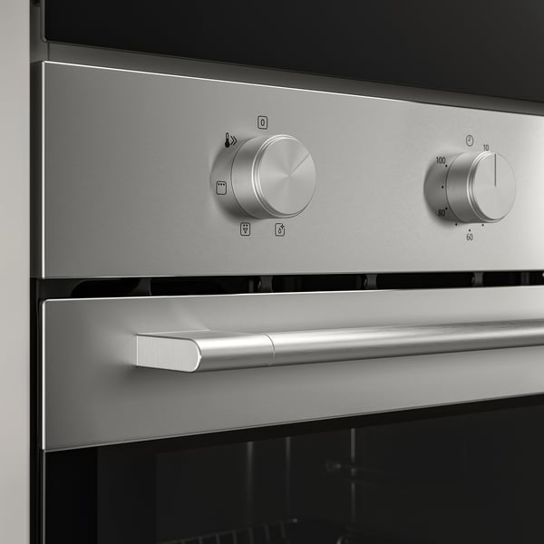Stainless steel oven controls; large silver knobs, one with temperature markings.