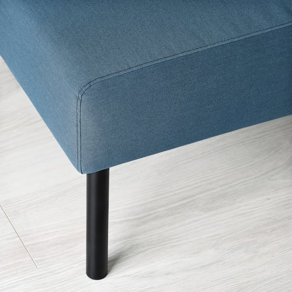 Blue fabric-covered footstool with black metal leg on a light wooden floor.