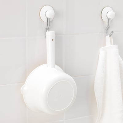 Wall-mounted white container with handle, likely for holding small items in a bathroom.