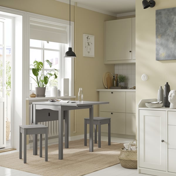 Small grey HAUGA dining set with table and stools in compact kitchen, modern design with natural wood and minimalist style.