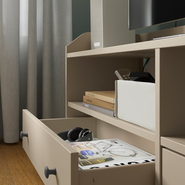 Open drawers reveal stored items like headphones and magazines. Designed for organised living.