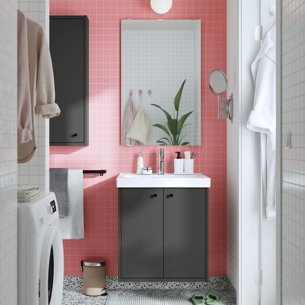 A modern bathroom with a grey HAVBÄCK vanity, white sink, dark handles, and green plant.