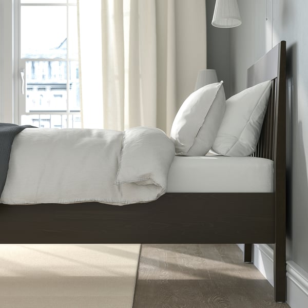 Modern bedroom with IDANÄS bed, white/gray linens, large window.