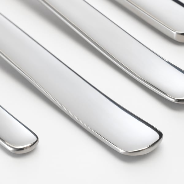 Polished silverware neatly arranged, showcasing smooth, reflective surfaces and sleek edges.