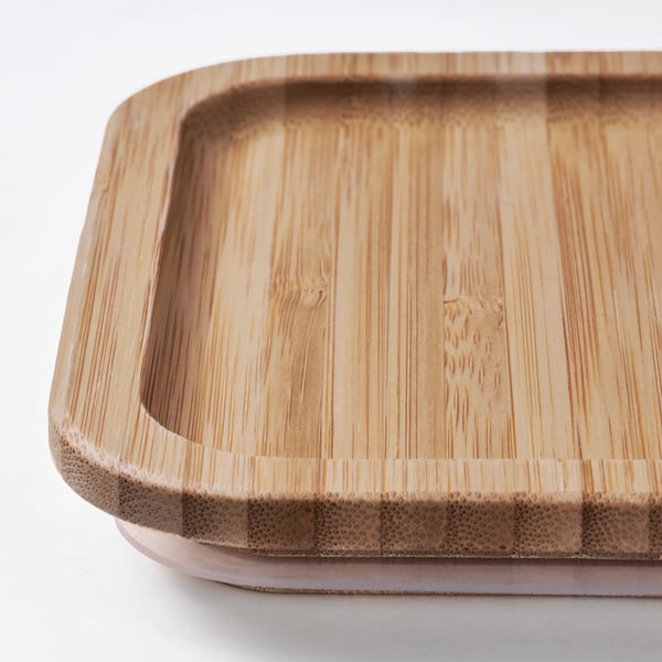 Bamboo lid with grips and tight seals for secure food storage.