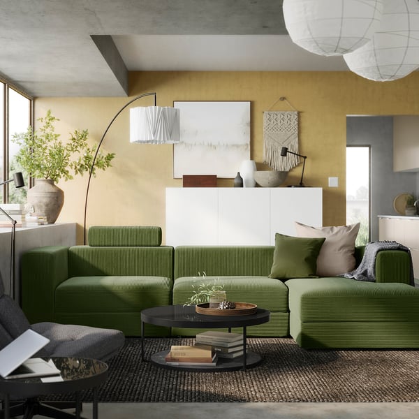 Modern living room with green JÄTTEBO sofa, yellow walls, boho decor, and minimalist lighting.