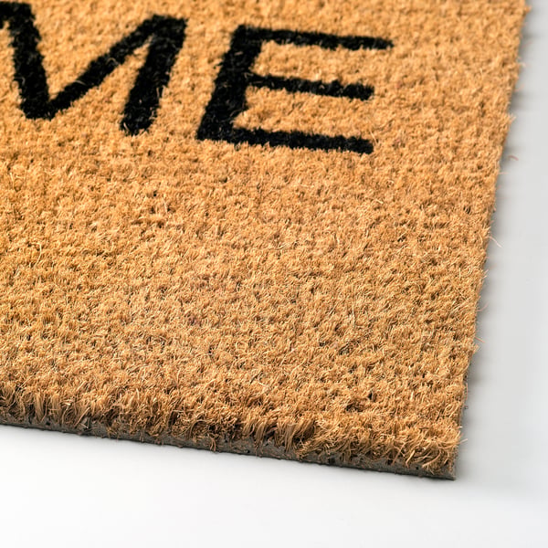 Doormat with bold welcome text, made of durable coir fibres, natural latex backing, placed on a flat surface.