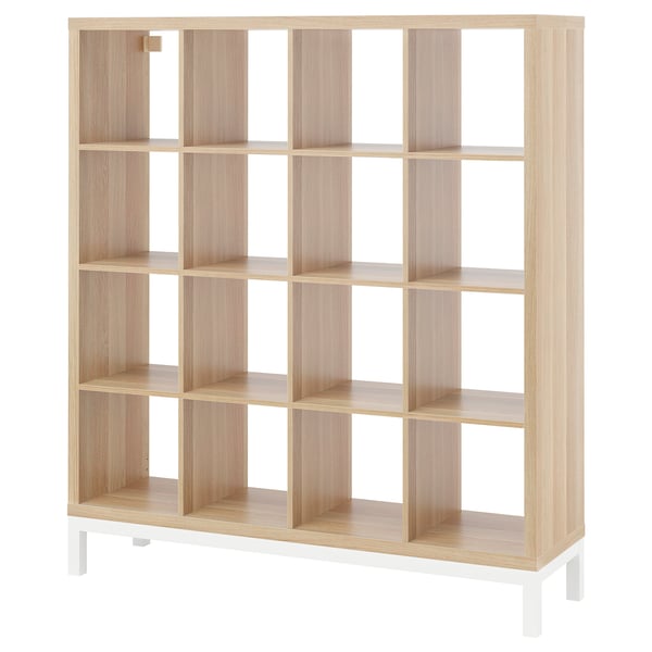 A KALLAX light brown cube shelf with white legs. It has a minimalist design with multiple square compartments for storage.