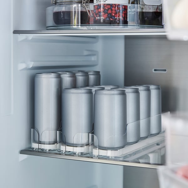 Open fridge with cans in organised holders, top shelf; efficient storage and easy access.