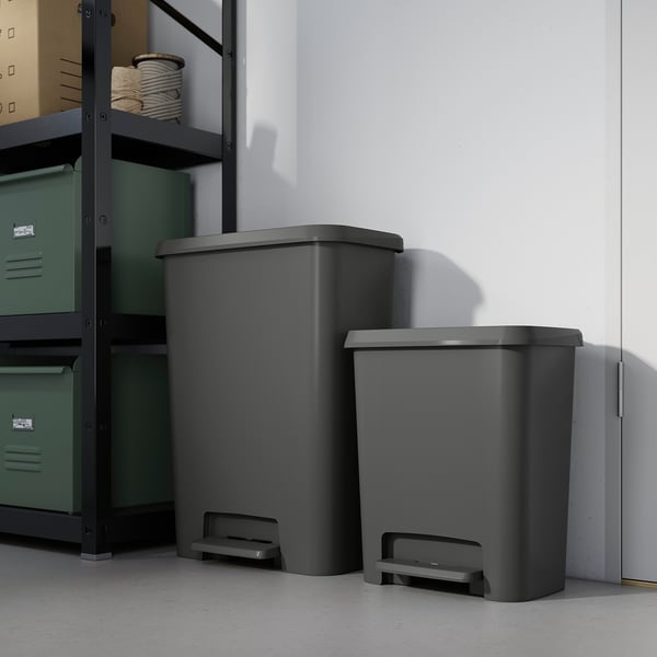 Two grey KNÖCKLA bins beside green shelving for waste sorting.
