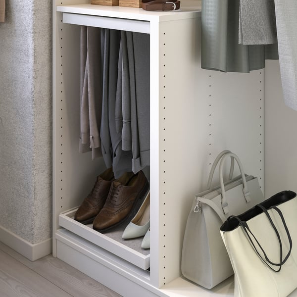 A white KOMPLEMENT wardrobe divider storing clothes and accessories.
