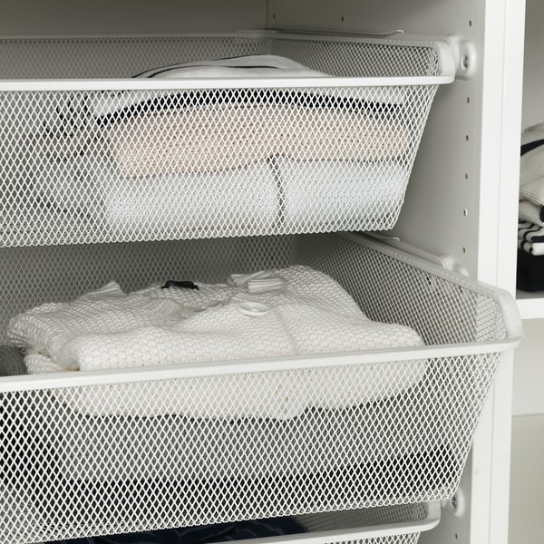 White cabinet holding clothes in mesh baskets, allowing air circulation for fresh storage.