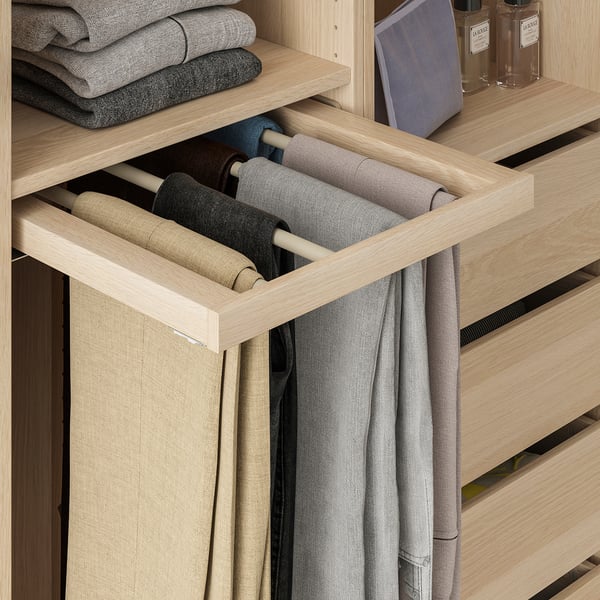 Wooden wardrobe organiser with hanging trousers and neatly folded clothes.