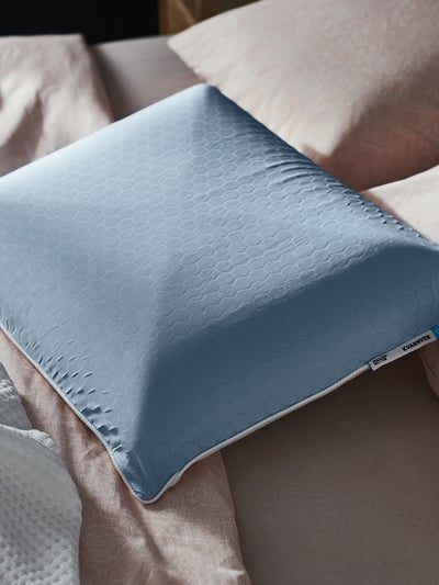 A blue cooling pillow, named KVARNVEN, with a honeycomb pattern on one side and memory foam on the other, designed for side and back sleepers.