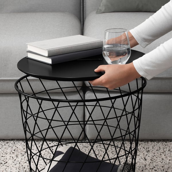 Person with wine glass, modern side table & books.