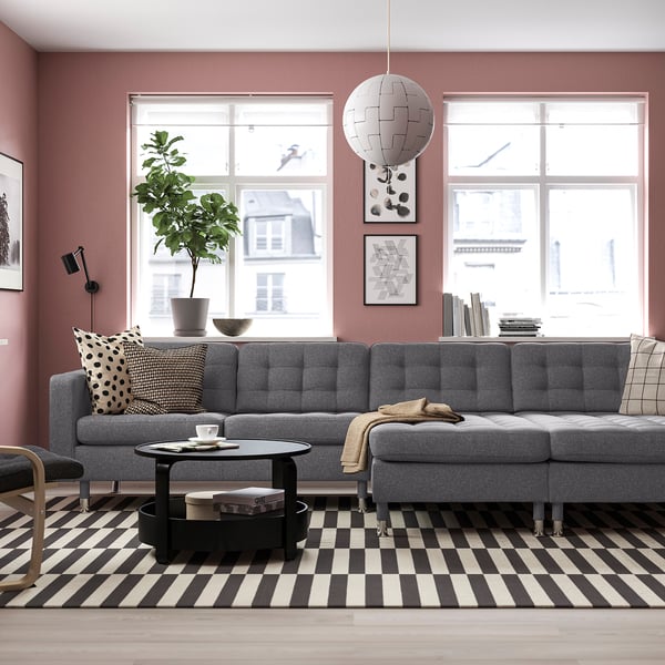 Modern living room with grey LANDSKRONA sofa, black & white striped rug, large window, and decorative hanging light.