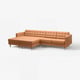 Tan leather l-shaped sectional sofa with chrome legs, button-tufted cushions.