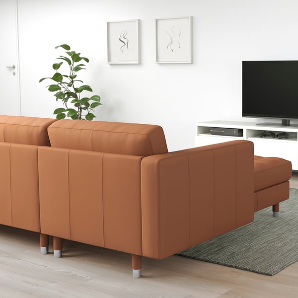 Modern IKEA sectional sofa in living room with tv and plant.