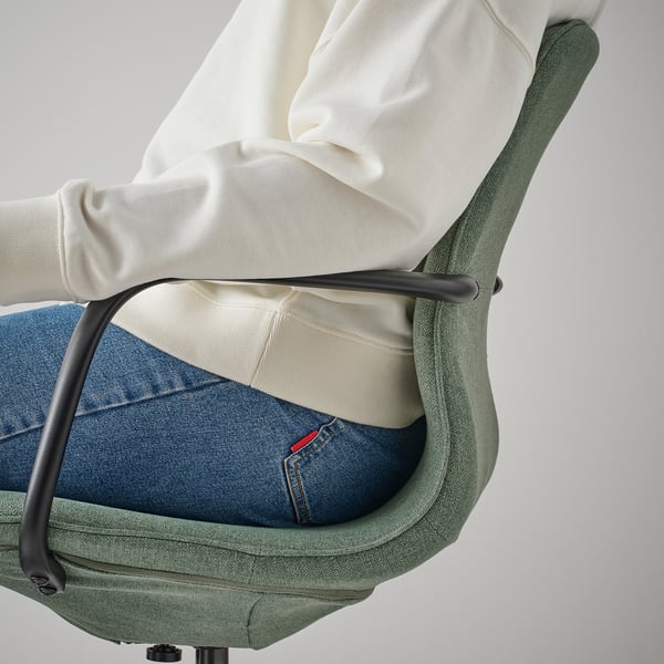 Person sitting in green LÅNGFJÄLL office chair, showing lumbar support and adjustable seat height.