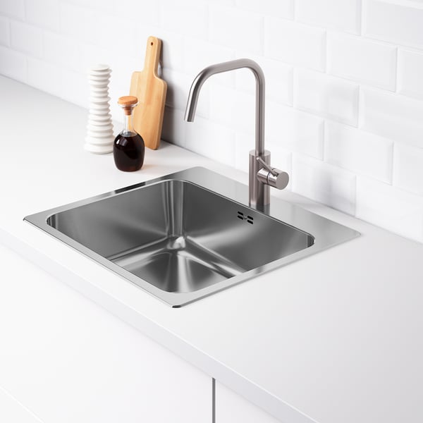 Stainless steel sink with modern tap in sleek kitchen setup.