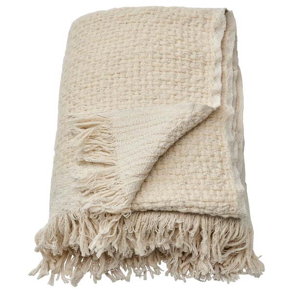 Folded beige handwoven throw blanket with fringes. Made from cotton and wool, soft and warm.